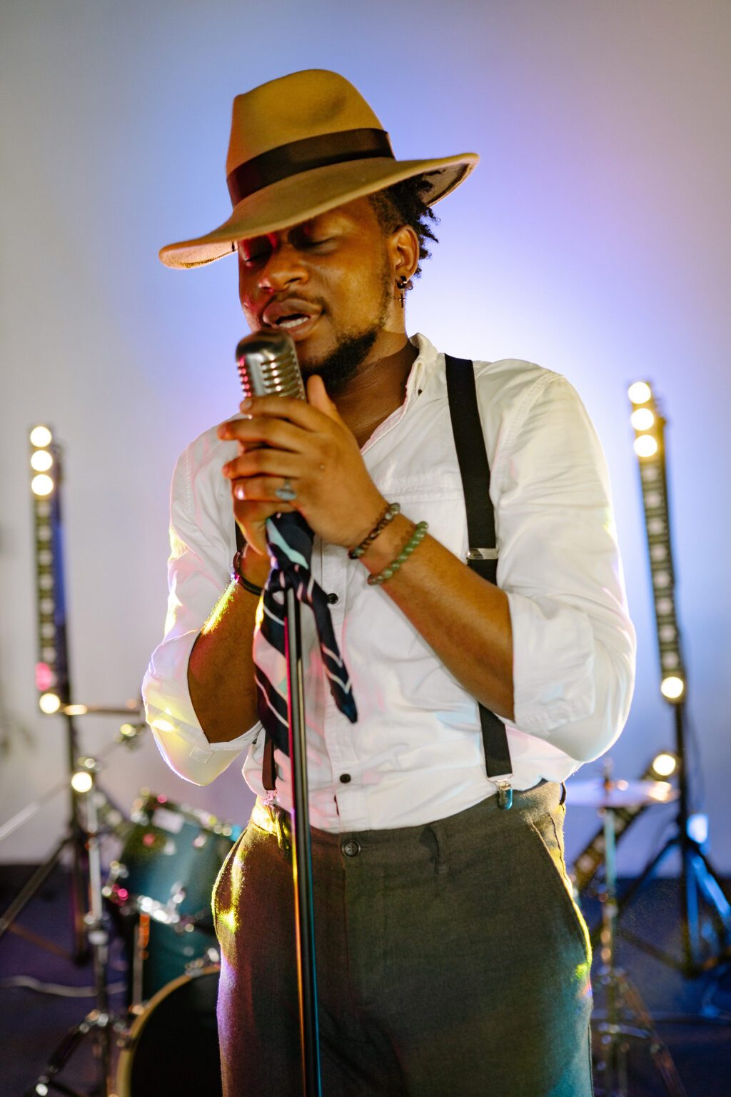 A man in a hat singing into a microphone.